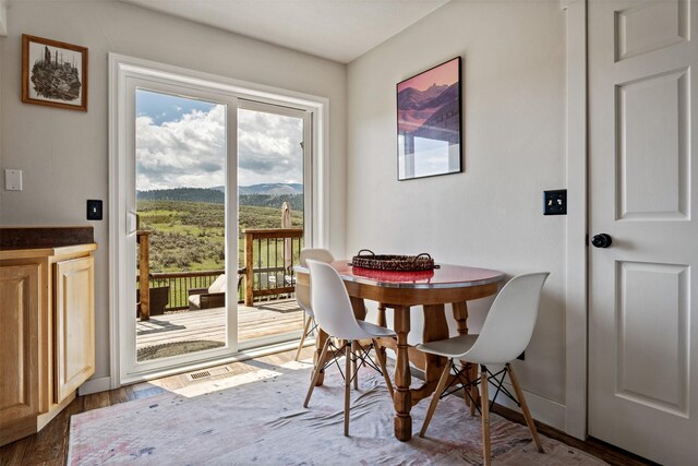 dining space with a mountain view and wood finished floors