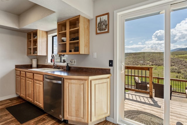 interior space with dark wood-style flooring, dishwasher, a sink, baseboards, and a mountain view