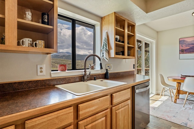 kitchen with stainless steel dishwasher, open shelves, a sink, and light wood-style floors