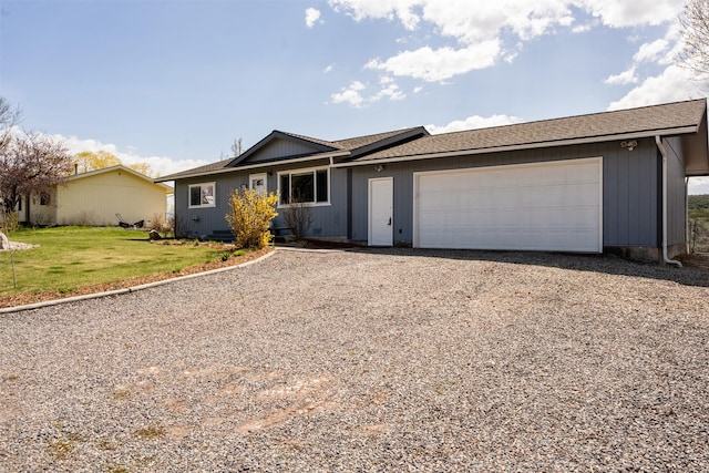 9225 Sharptail Dr, Missoula, MT 59808 - ranch-style home with driveway, a front lawn, an attached garage, and a shingled roof