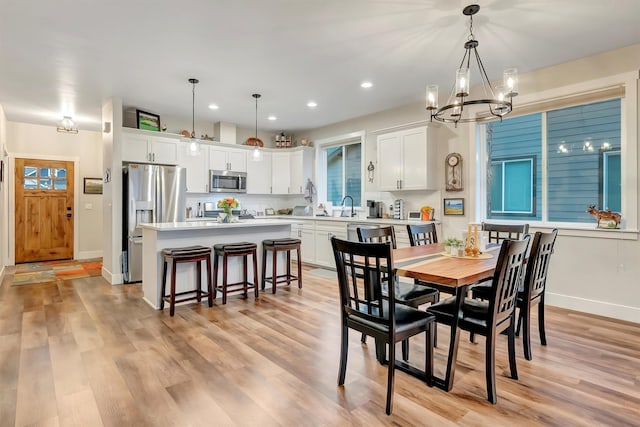 dining area featuring recessed lighting, baseboards, an inviting chandelier, and light wood finished floors