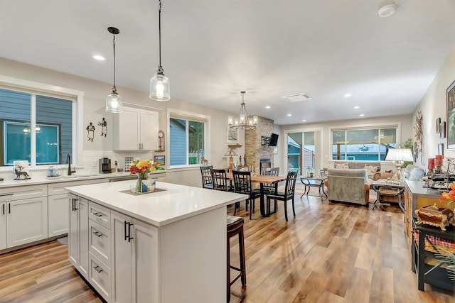11469 Ninebark Way, Missoula, MT 59802 - kitchen featuring white cabinets, a kitchen bar, light countertops, a kitchen island, and healthy amount of natural light