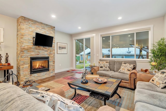 living area with recessed lighting, baseboards, wood finished floors, and a fireplace