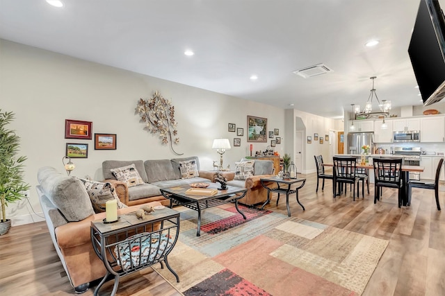 living room with recessed lighting, a notable chandelier, light wood-type flooring, and visible vents