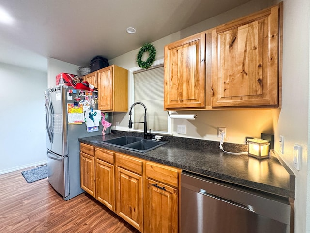 8626 Snapdragon Dr, Missoula, MT 59808 - kitchen with stainless steel appliances, dark countertops, wood finished floors, and brown cabinetry