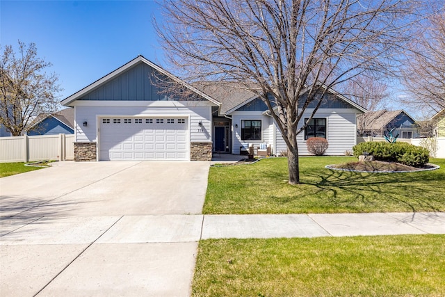 craftsman-style home with a garage, fence, concrete driveway, and stone siding