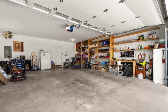 154 Taelor Rd, Kalispell, MT 59901 - garage with electric panel, freestanding refrigerator, and a garage door opener