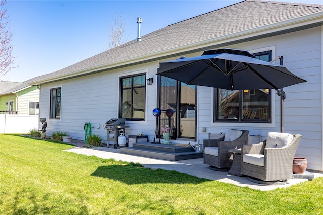 back of house featuring a lawn, roof with shingles, fence, and a patio area