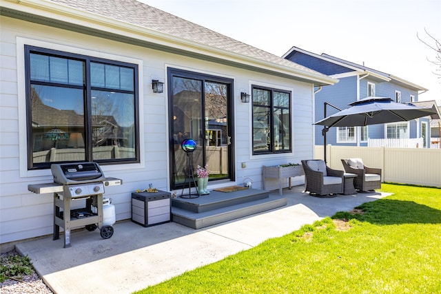 back of property with a lawn, fence, a patio area, and roof with shingles