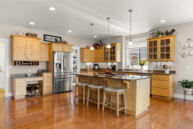 kitchen featuring appliances with stainless steel finishes, a kitchen island, recessed lighting, and a kitchen bar