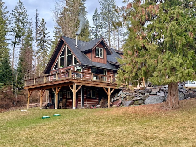 rear view of house featuring a wooden deck and a yard