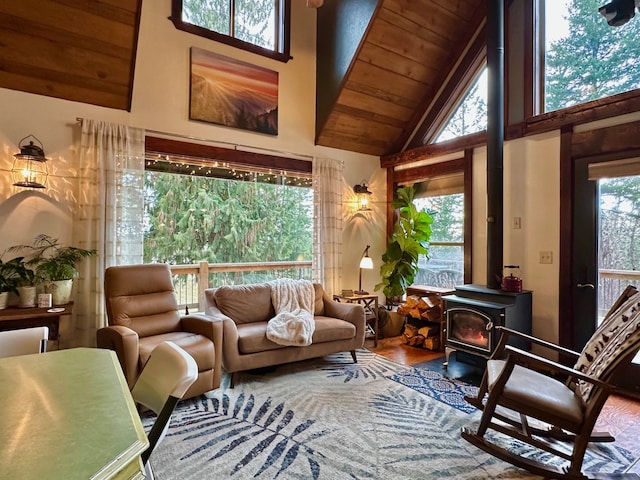 interior space featuring a wood stove, wood ceiling, and high vaulted ceiling
