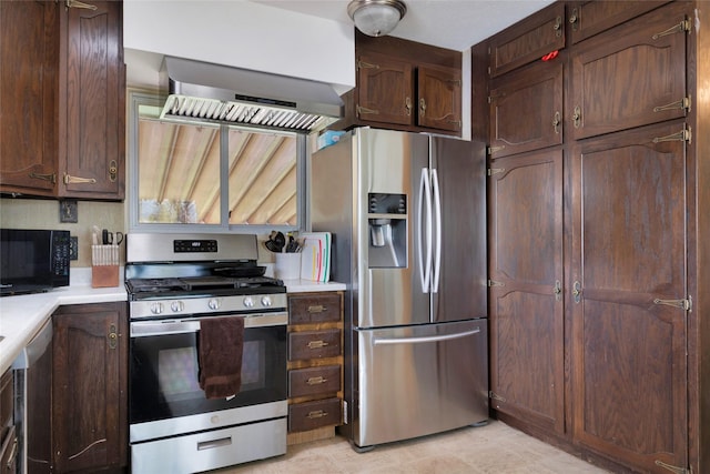 kitchen with light countertops, appliances with stainless steel finishes, wall chimney exhaust hood, and dark brown cabinets