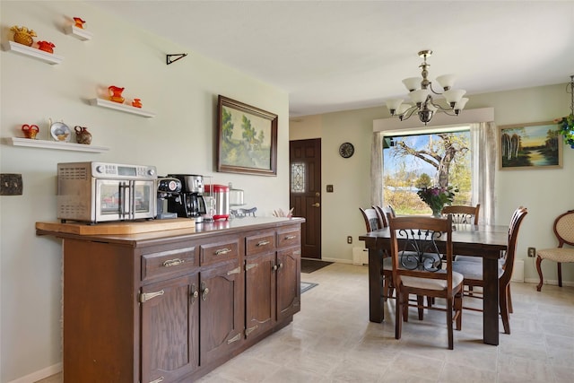 dining area featuring baseboards and a notable chandelier