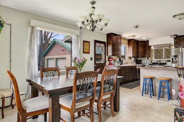 dining area featuring a baseboard heating unit and a chandelier