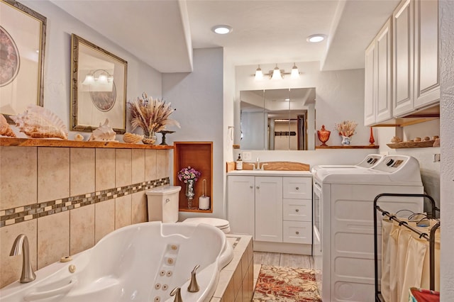 1317 River Rd, Missoula, MT 59801 - bathroom with washing machine and clothes dryer, a jetted tub, and vanity