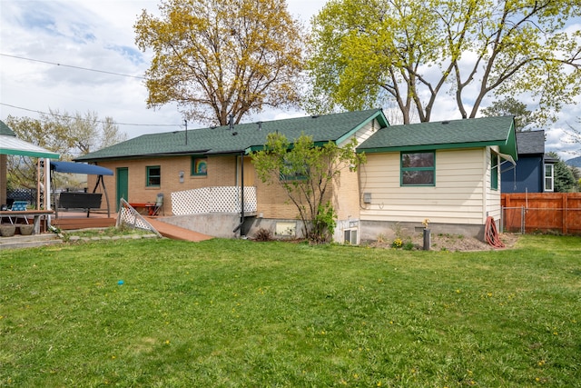 back of house featuring a lawn and fence