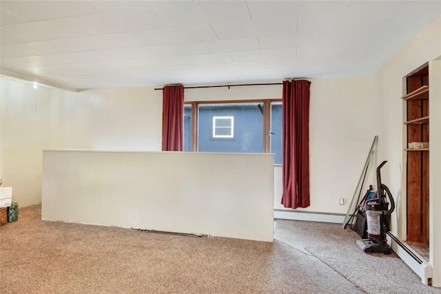 interior space with carpet floors, baseboard heating, and a baseboard heating unit