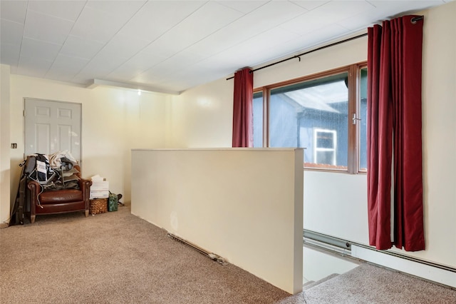 sitting room featuring an upstairs landing, carpet, and a baseboard radiator