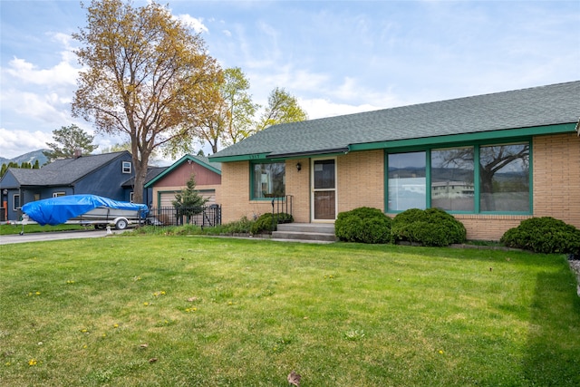1317 River Rd, Missoula, MT 59801 - view of front facade featuring brick siding, a front yard, roof with shingles, and a garage