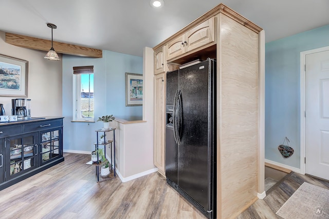 kitchen featuring decorative light fixtures, light brown cabinetry, baseboards, black refrigerator with ice dispenser, and light wood-style flooring