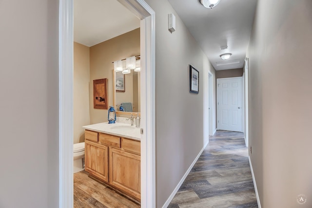 hallway featuring light wood-type flooring and a sink
