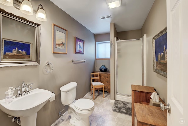 bathroom with visible vents, toilet, baseboards, a shower stall, and a sink