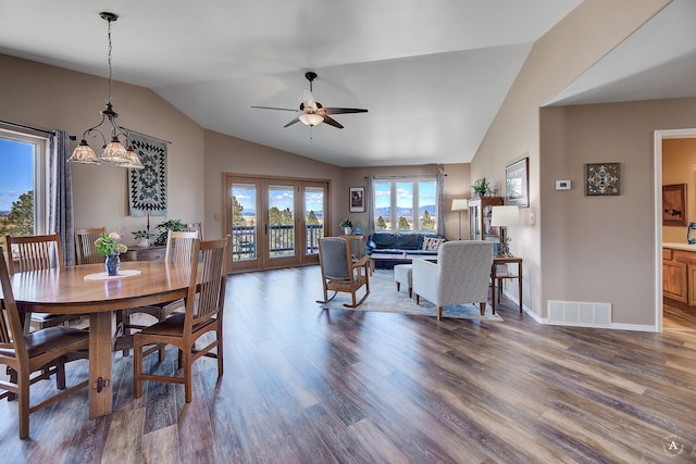 dining area featuring visible vents, wood finished floors, french doors, ceiling fan with notable chandelier, and vaulted ceiling