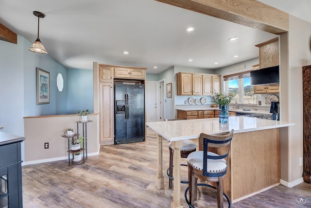 kitchen featuring light wood finished floors, black refrigerator with ice dispenser, range, and light brown cabinets