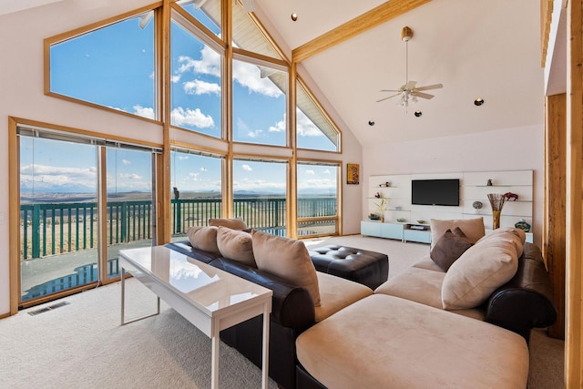 living area with carpet floors, visible vents, ceiling fan, high vaulted ceiling, and a water view
