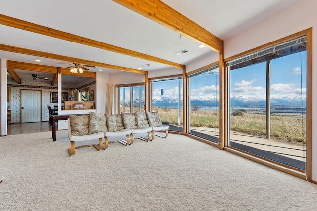 unfurnished living room with a ceiling fan, visible vents, beamed ceiling, carpet, and recessed lighting
