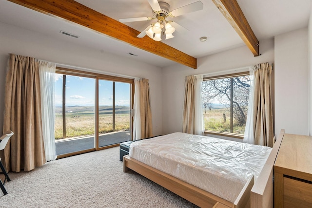 carpeted bedroom featuring beamed ceiling, visible vents, and multiple windows