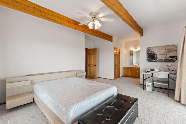 bedroom featuring baseboards, light carpet, ensuite bath, and beam ceiling