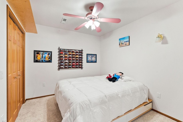 carpeted bedroom with visible vents, baseboards, and ceiling fan