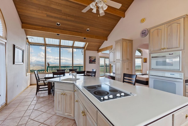 kitchen with wood ceiling, ceiling fan, black electric cooktop, light countertops, and a sink