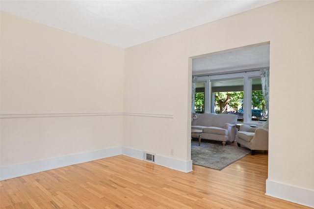 spare room featuring visible vents, light wood-style floors, and baseboards