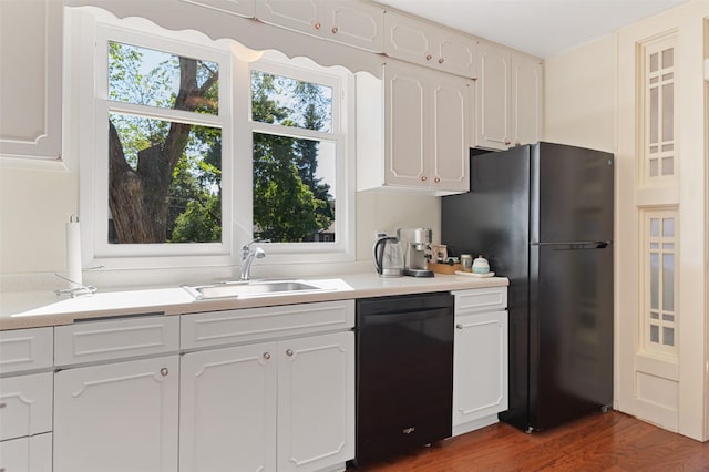 kitchen featuring light countertops, white cabinetry, a sink, and black appliances
