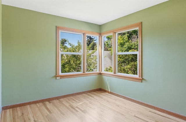 unfurnished room featuring baseboards and light wood-style floors