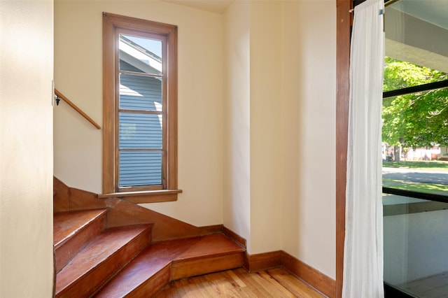 staircase featuring baseboards and wood finished floors