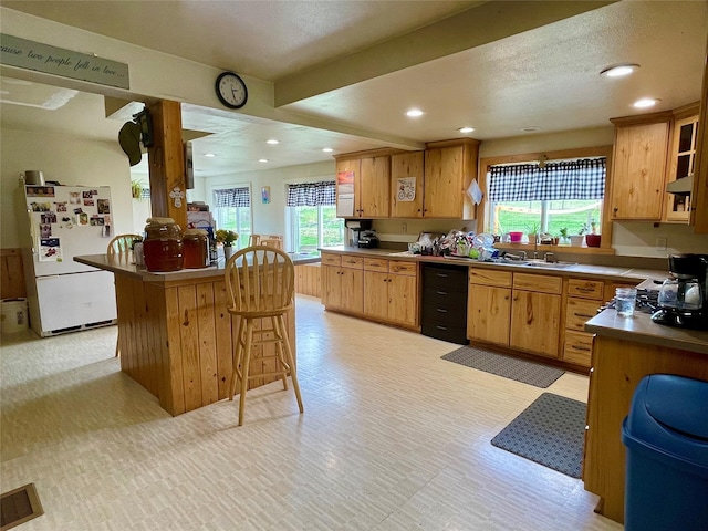 kitchen featuring visible vents, freestanding refrigerator, light floors, a breakfast bar, and recessed lighting