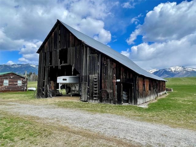 view of barn featuring a lawn and a mountain view