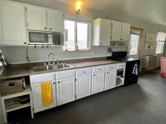 kitchen featuring a sink, white cabinets, white microwave, and electric range