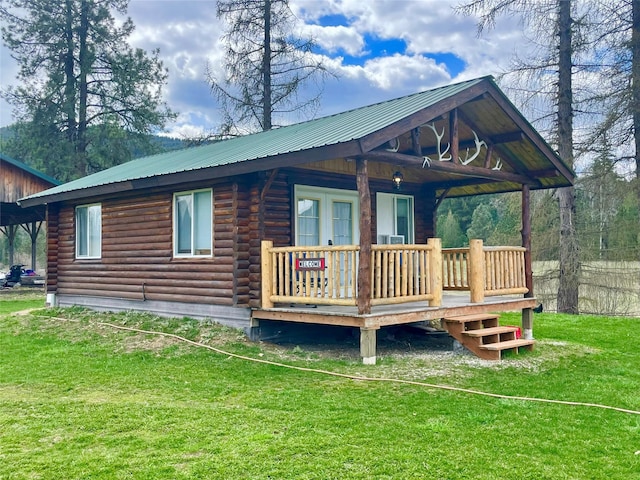 back of property with a lawn, log exterior, and metal roof