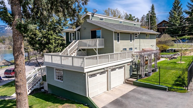 view of front of house featuring an attached garage, a front lawn, stairs, and a balcony