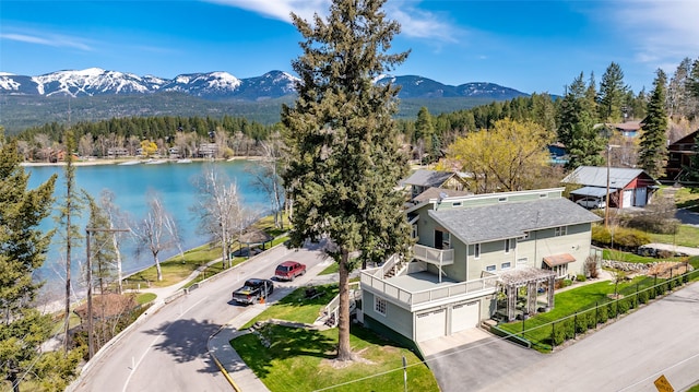 drone / aerial view featuring a water and mountain view and a wooded view