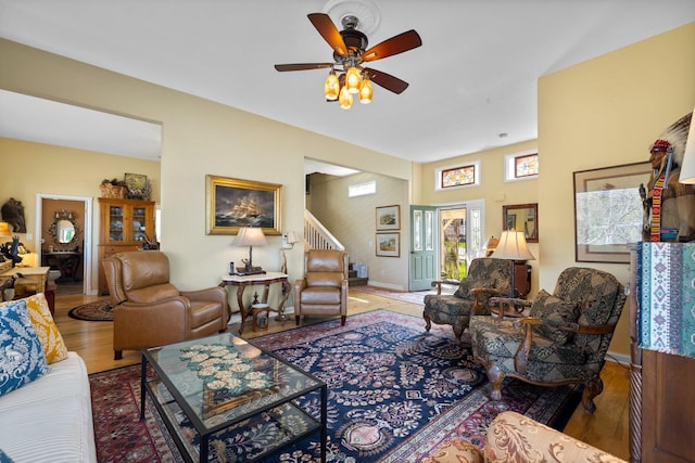 living room with stairway, baseboards, a ceiling fan, and wood finished floors