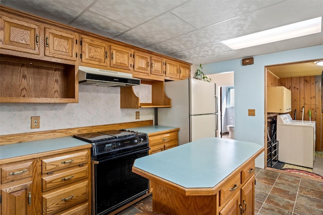 226 S Davis St, Missoula, MT 59801 - kitchen with freestanding refrigerator, black range, light countertops, under cabinet range hood, and independent washer and dryer