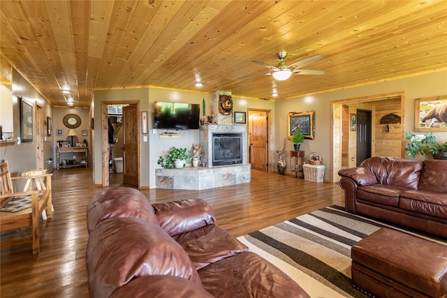 living area with a ceiling fan, a fireplace, wood finished floors, and wooden ceiling