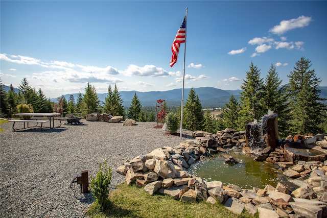 property view of mountains featuring a small pond