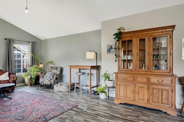sitting room featuring baseboards, wood finished floors, and lofted ceiling
